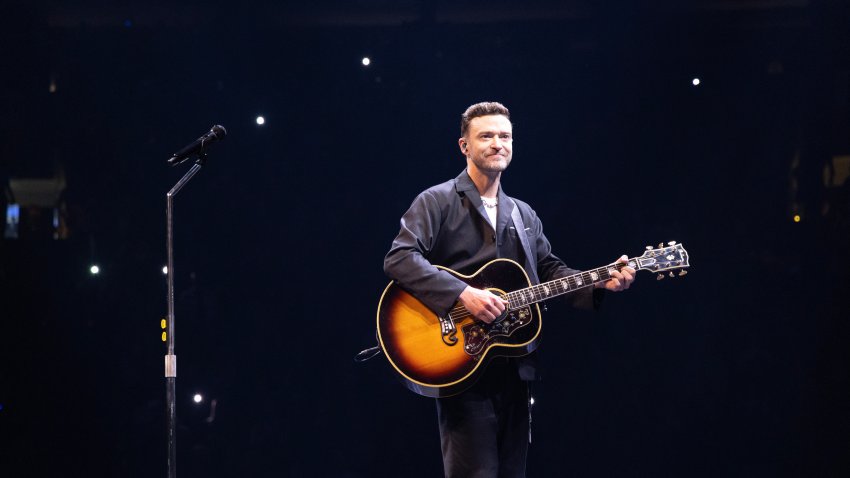 Justin Timberlake play guitar on stage.