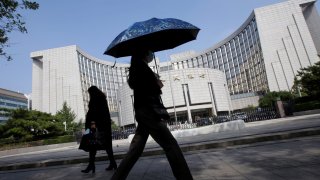 People walk past the headquarters of the People’s Bank of China (PBOC), the central bank, in Beijing, China September 28, 2018. 