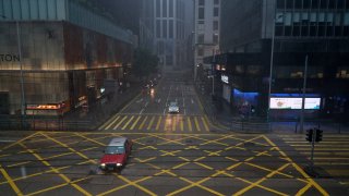 HONG KONG, CHINA – OCTOBER 13: A taxi crosses an empty intersection in the Central business district during a No. 8 Storm signal raised for Typhoon Kompasu, the 18th typhoon of this year, on October 13, 2021 in Hong Kong, China.