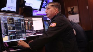 Traders work on the floor of the New York Stock Exchange during afternoon trading on March 27, 2024.