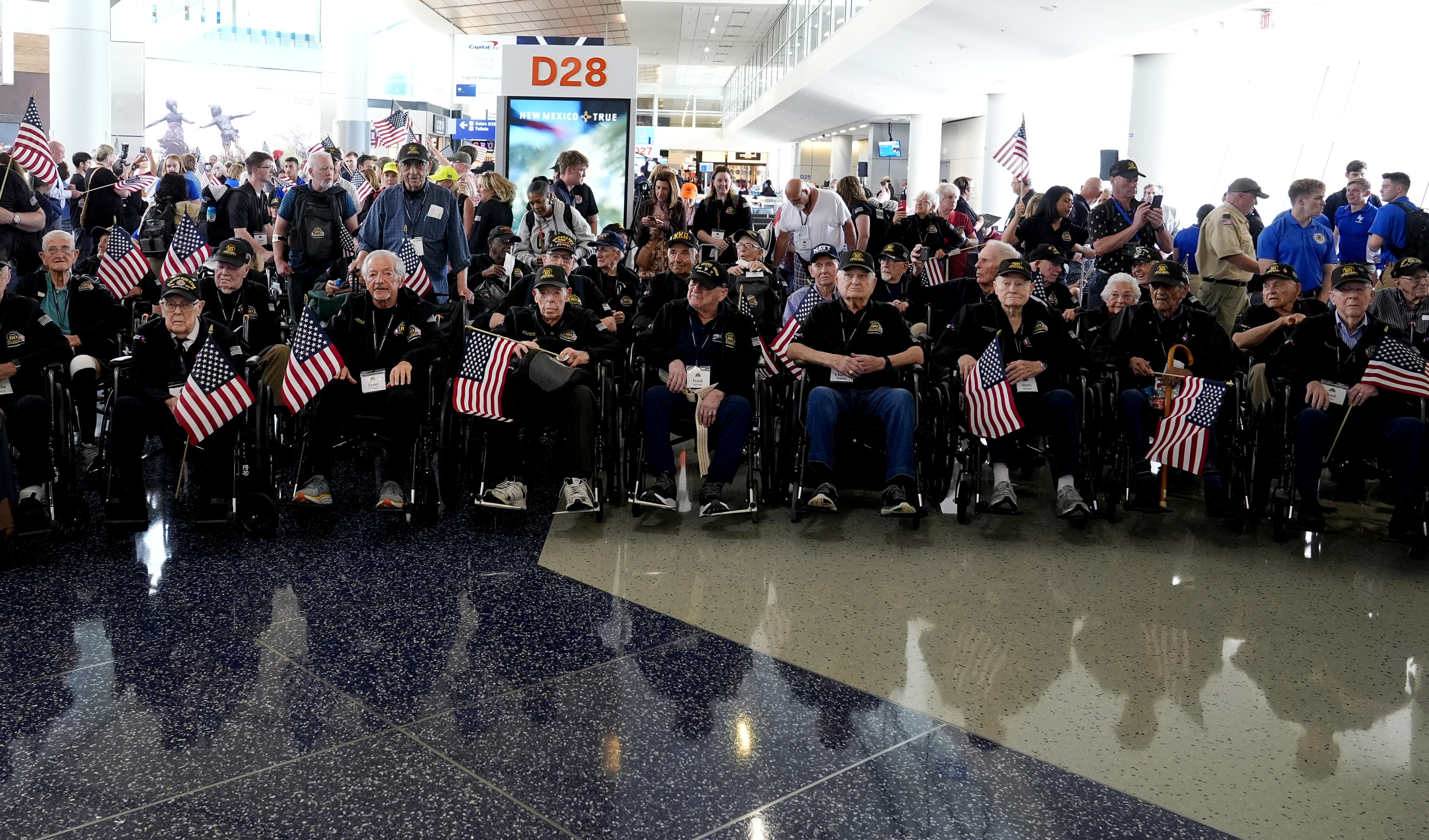 A group of World War II veterans wait to board a plane at Dallas Fort Worth International Airport in Dallas, Texas, Friday, May 31, 2024. 