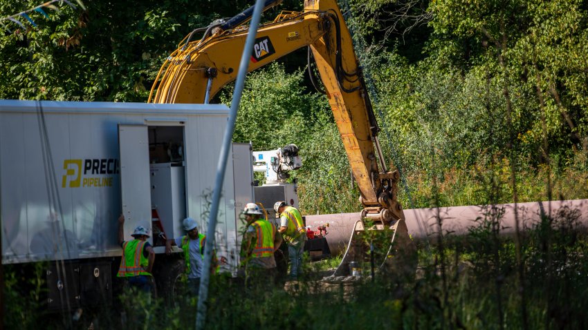 A work crew for Precision Pipeline Company discusses the placement of a section of the Mountain Valley Pipeline.