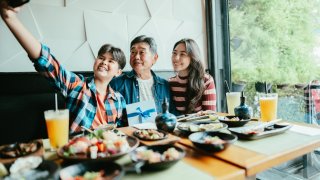 Family taking a selfie at sushi bar