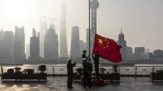 China customs officers raising a Chinese flag during a rehearsal for a flag-raising ceremony in Shanghai.