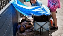 Dr. Matt Essary checks on a homeless man who fell ill on the sidewalk outside one of five Circle The City mobile clinics stationed outside soup kitchens and other services for homeless people, Thursday, May 30, 2024 in Phoenix. Based in the hottest big metro in America, Circle the City is taking measures to protect patients from life-threatening heat illness as temperatures hit new highs. Homeless people accounted for nearly half of the record 645 heat-related deaths last year in Arizona's Maricopa County, which encompasses metro Phoenix.(AP Photo/Matt York)