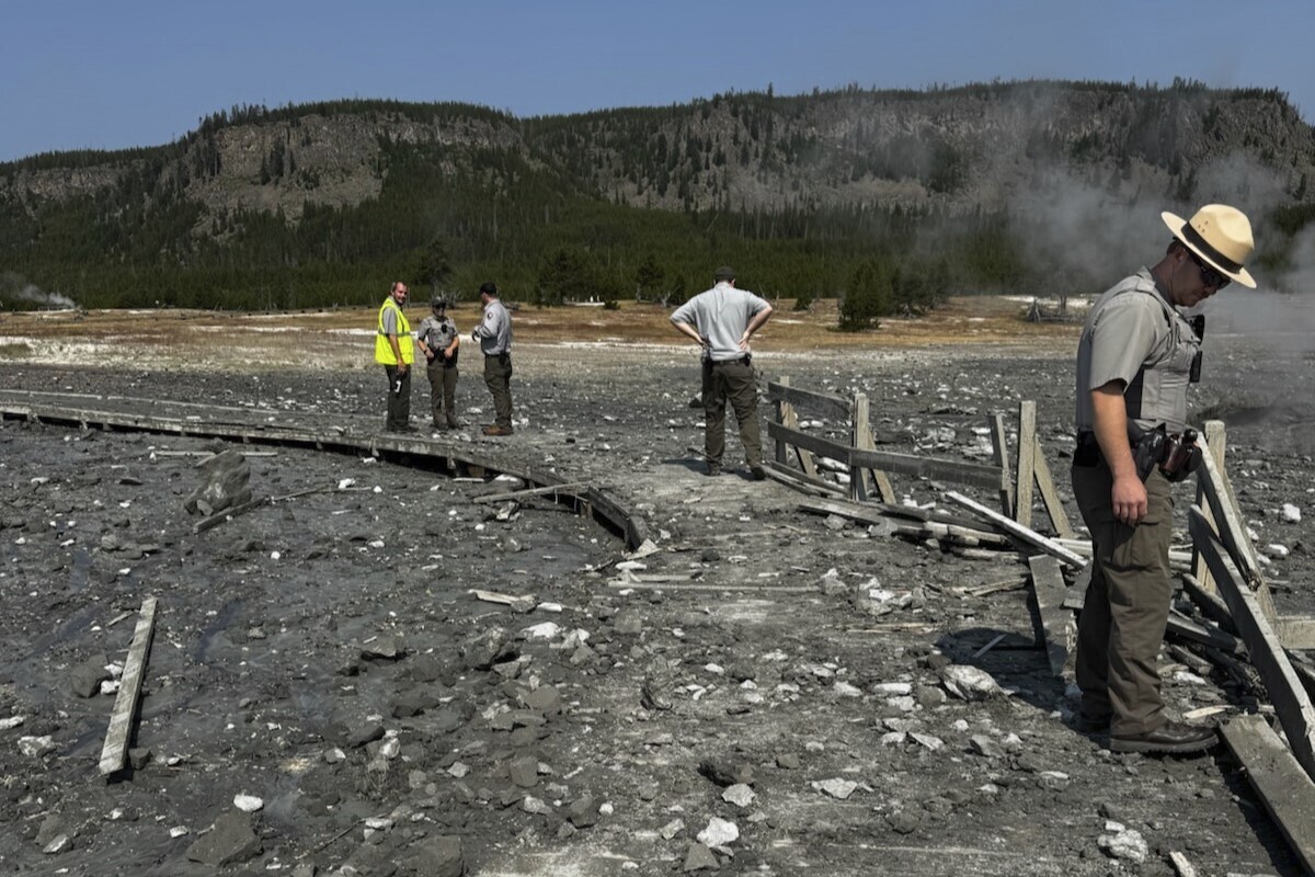 In this photo released by the National Park Service, park staff assess the damage to Biscuit Basin boardwalks after a hydrothermal explosion at Biscuit Basin in Yellowstone National Park, Wyo., Tuesday, July 23, 2024. (National Park Service via AP)