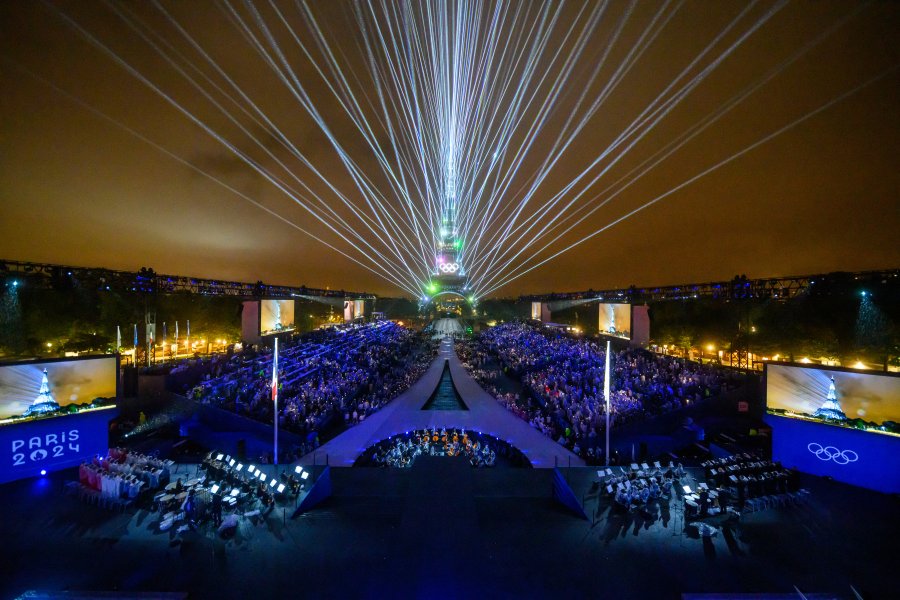 Overview of the Trocadero venue, with the Eiffel Tower looming in the background and lasers lighting up the sk