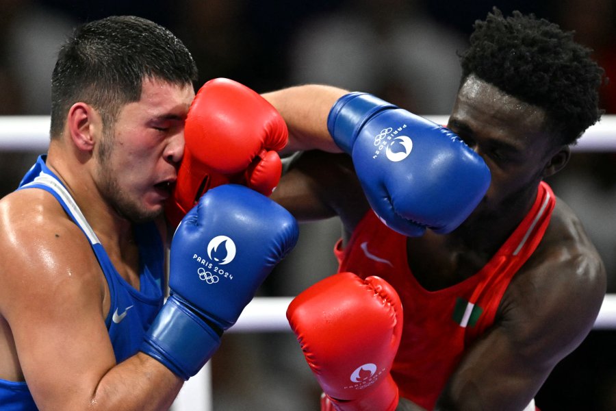 Kazakhstan's Aibek Oralbay (in blue) fights against Nigeria's Olaitan Adam Olaore in the men's 92kg preliminaries round of 16 boxing