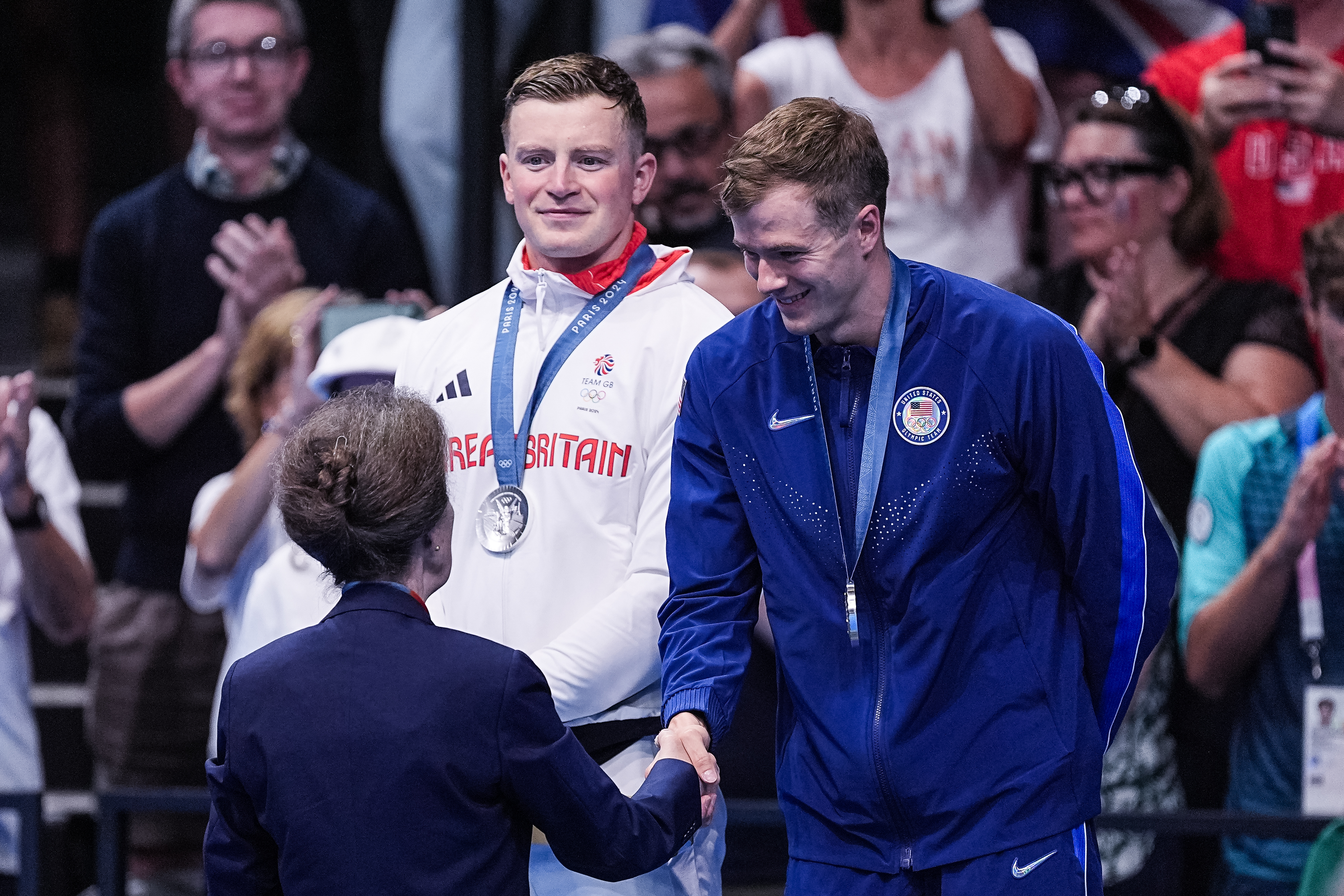 Nic Fink shakes hand with silver medal around his neck.