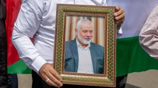 Members of Tehran University Council attend a protest to condemn the killing of Hamas leader Ismail Haniyeh, as they carry Iranian and Palestinian flags at Tehran University, July 31, 2024 in Tehran, Iran. Hamas political leader, Ismail Haniyeh, was killed in an airstrike in Tehran after attending the inauguration of Iran's new president. Israel has yet to claim responsibility for his death.