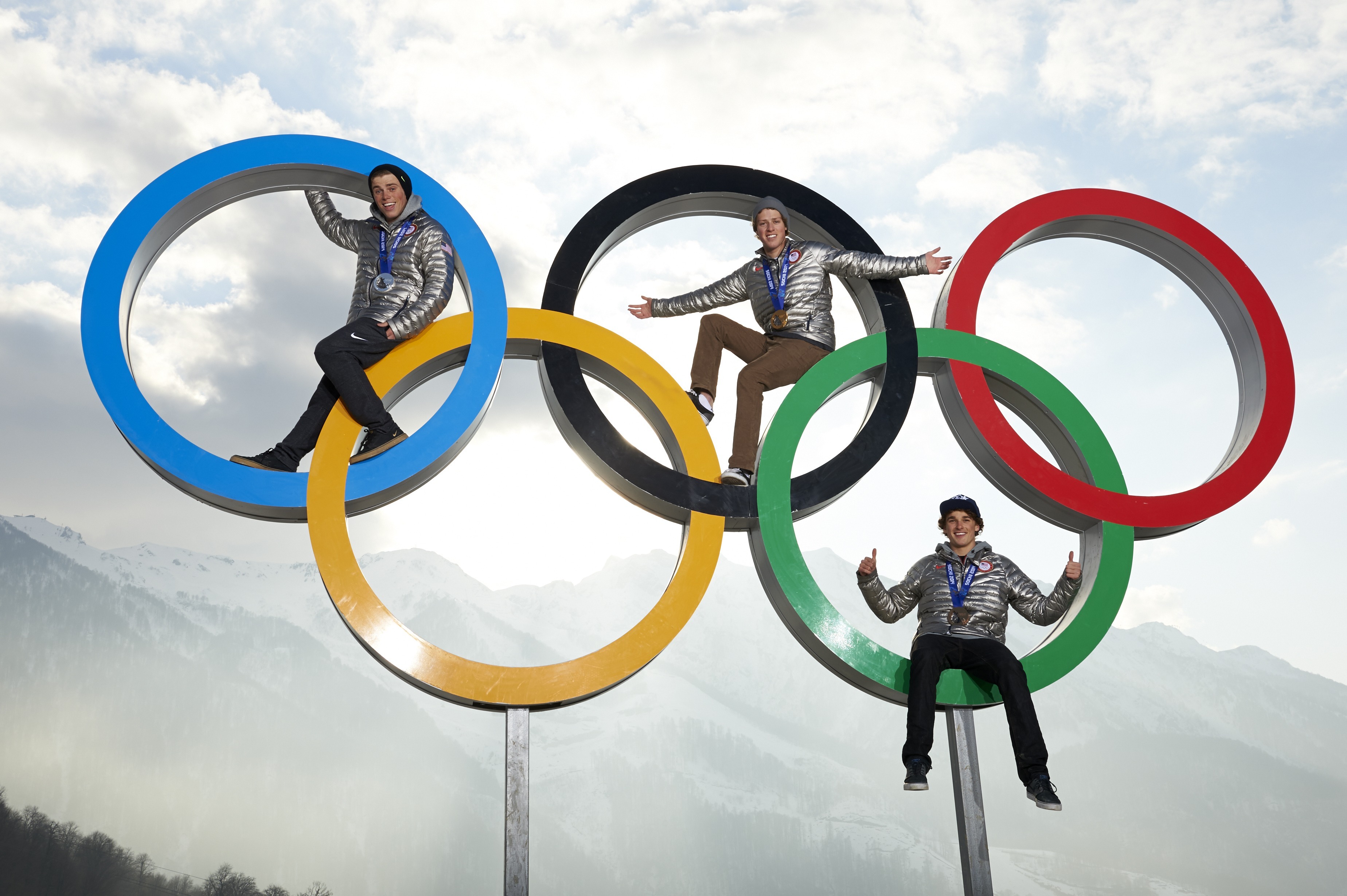 Gus Kenworthy (silver), Joss Christensen (gold), and Nicholas Goepper (bronze) posing on Olympic rings