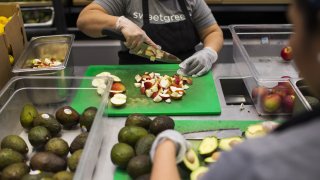 Workers prepare apples and avocados inside a Sweetgreen Inc. restaurant.