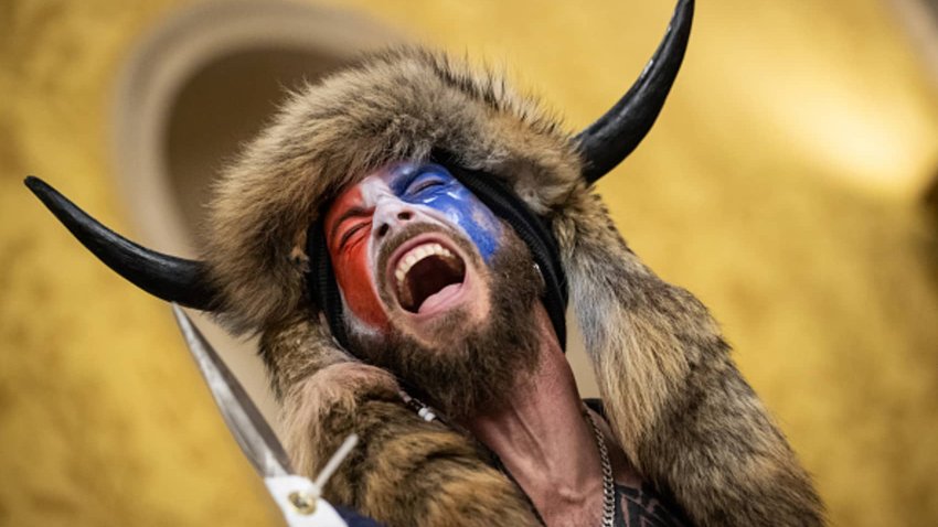 Jacob Chansley, also known as the “QAnon Shaman,” screams “Freedom” inside the U.S. Senate chamber after the U.S. Capitol was breached by a mob during a joint session of Congress on January 6, 2021 in Washington, DC.