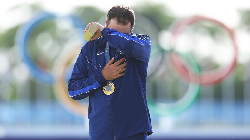 Gold medalist, Scottie Scheffler of Team United States reacts on the podium