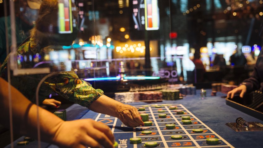 Visitors reach under a plastic shield to place their bets at a roulette table at Ocean Casino Resort in Atlantic City, New Jersey, U.S., on Thursday, July 2, 2020. Atlantic City gambling, dealt a blow by newly opened betting markets in other states, was enjoying a slow comeback when Murphy ordered all nine casinos closed on March 16.