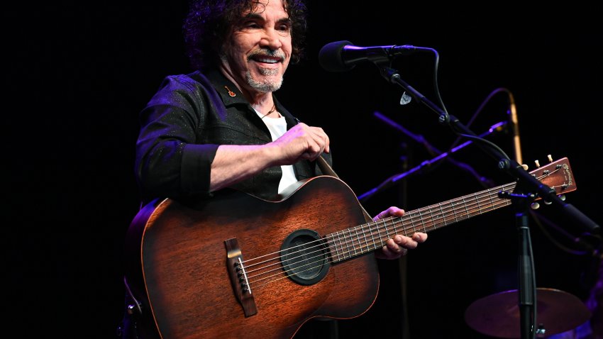 John Oates smiling while holding guitar