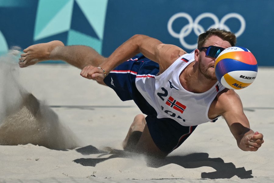 Norway's #02 Christian Sandlie Soerum dives to reach the ball in their men's round of 16 beach volleyball match