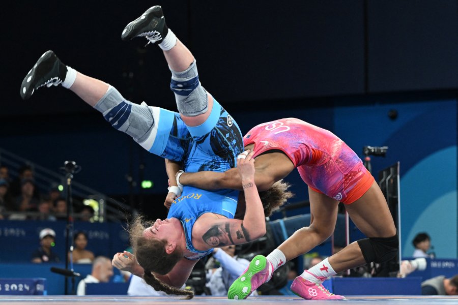 US' Kennedy Alexis Blades (red) wrestles Romania's Catalina Axente (blue)