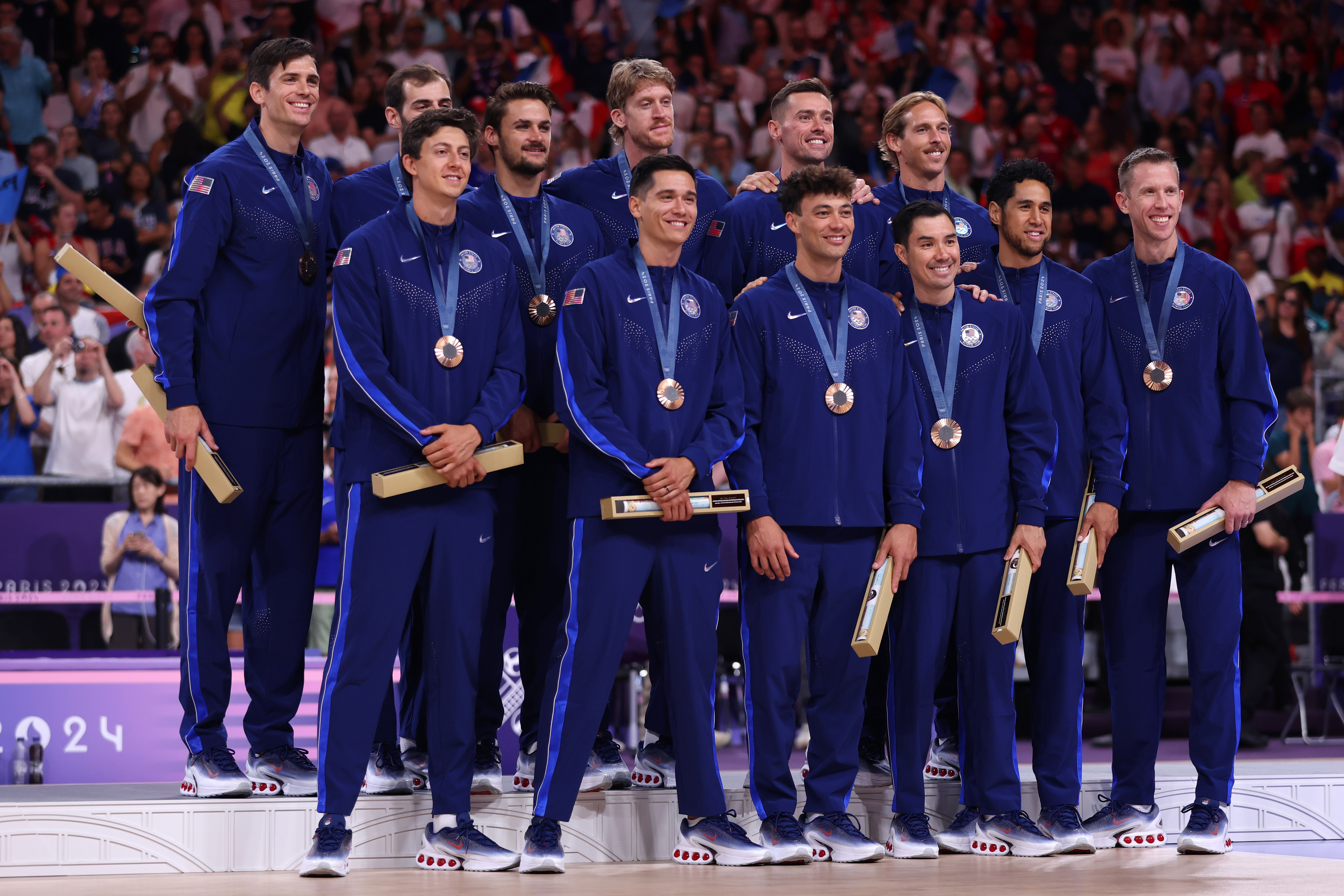 PARIS, FRANCE - AUGUST 10: Bronze medalists of Team United States celebrate on the podium during the Volleyball medal ceremony after the Men's Gold Medal Match on Day fifteen of the Olympic Games Paris 2024 at Paris Arena on August 10, 2024 in Paris, France. (Photo by Sarah Stier/Getty Images)