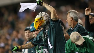 Philadelphia Eagles fan in bird hat waves towel.