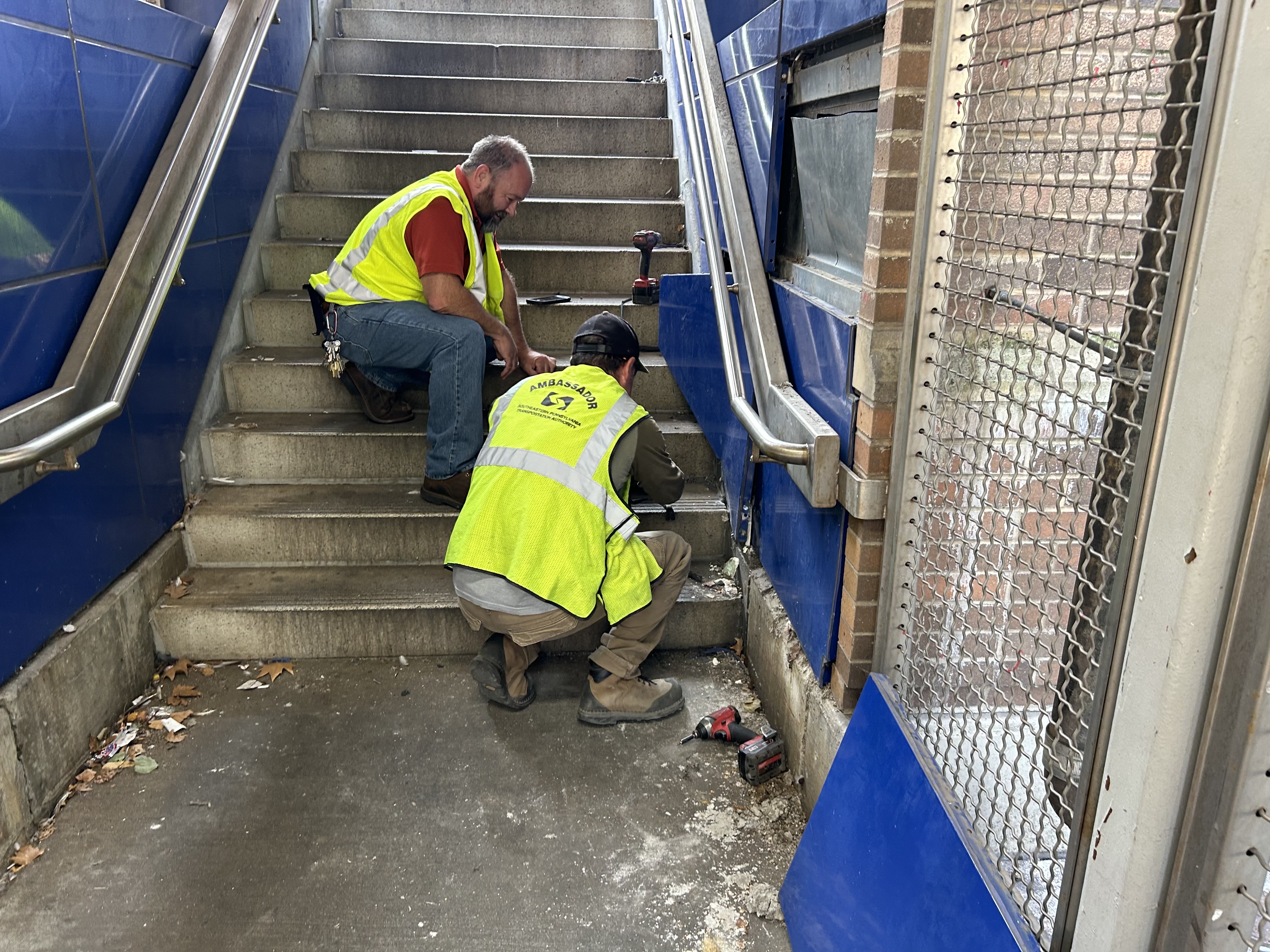 SEPTA employees work to free a kitten from the walls of the 63rd Street Station.