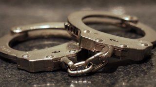 A close up shot of a pair of handcuffs on a table.