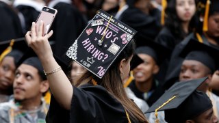 A City College of New York graduate takes a selfie during the school’s commencement ceremony.