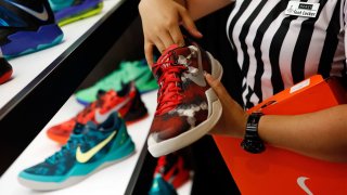 An employee arranges Nike basketball shoes on display at the House Of Hoops by Foot Locker retail store at the Beverly Center in Los Angeles.