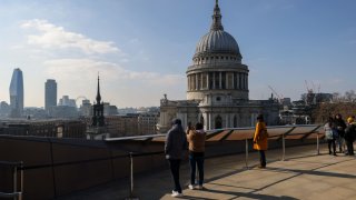 Visitors look out to St. Paul’s Cathedral from a rooftop in the City of London, UK.