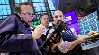 Traders work on the floor at the New York Stock Exchange on July 3, 2024.