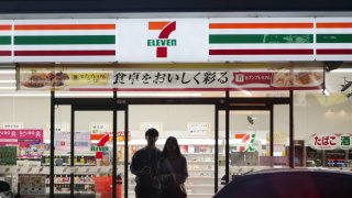 Customers exit a 7-Eleven convenience store, operated by Seven & i Holdings Co., in Kobe, Japan, on Friday, Aug. 30, 2024. Alimentation Couche-Tard Inc. had made a preliminary non-binding proposal to buy Seven & i, which operates more than 85,000 stores across the globe, and the deal would be the biggest-ever foreign takeover of a Japanese company. Photographer: Soichiro Koriyama/Bloomberg via Getty Images