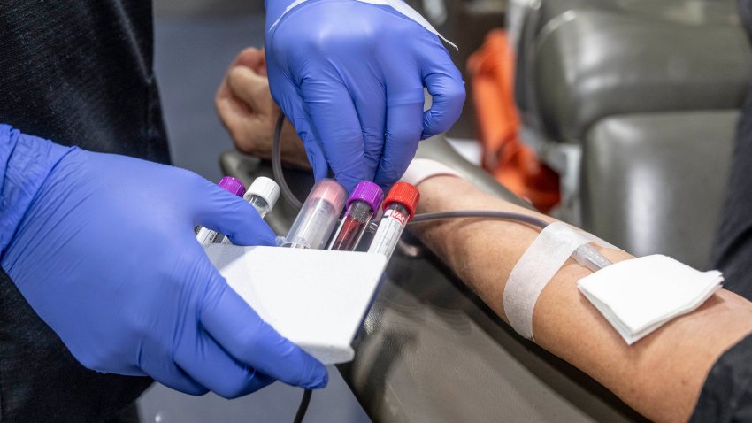 A nurse fills test tubes with blood