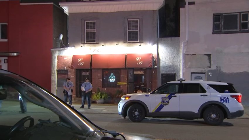 Police officers outside Charlie B's bar in Germantown after a worker was shot there on Sunday night.