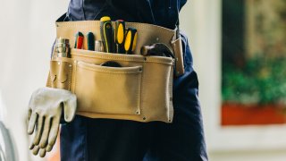 Close-up of handyman wearing a tool belt.