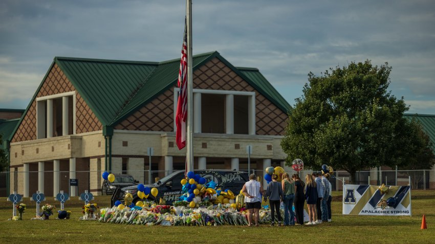 People pay respects at a memorial