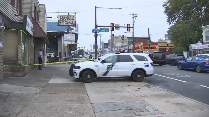 Police SUV on sidewalk in front of bar and SEPTA station.