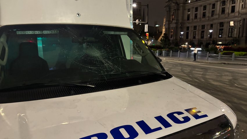 A police vehicle with a shattered windshield sits outside of City Hall after being damaged when officers responded to car meetups overnight.