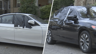 Two cars with their windows covered with black tarps