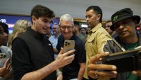 Apple CEO Tim Cook (C) joins customers during Apple’s iPhone 16 launch in New York on September 20, 2024. 