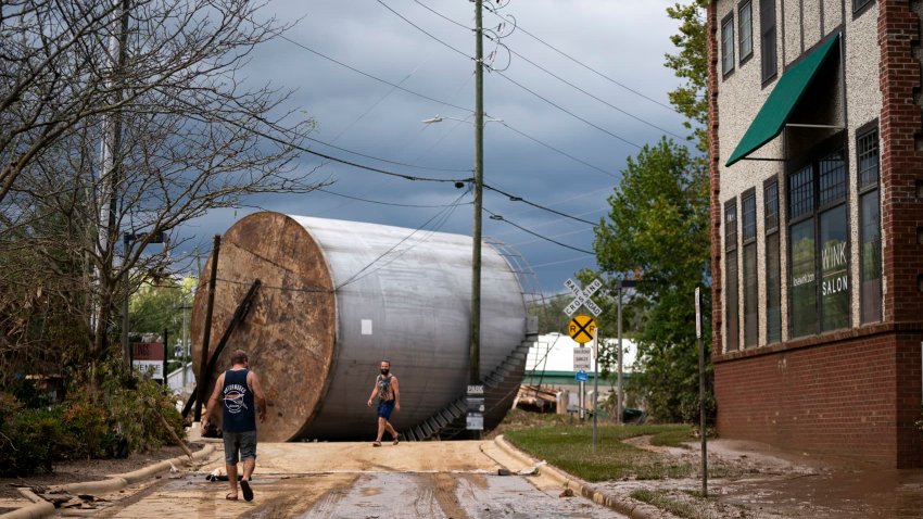 Men inspect the damage from flooding in the aftermath of Hurricane Helene on Sept. 28, 2024 in Asheville, North Carolina.