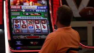 A man plays an NFL themed slot machine by Aristocrat Gaming in the Media Center ahead of the Super Bowl 58 NFL football game, Wednesday, Feb. 7, 2024, in Las Vegas.