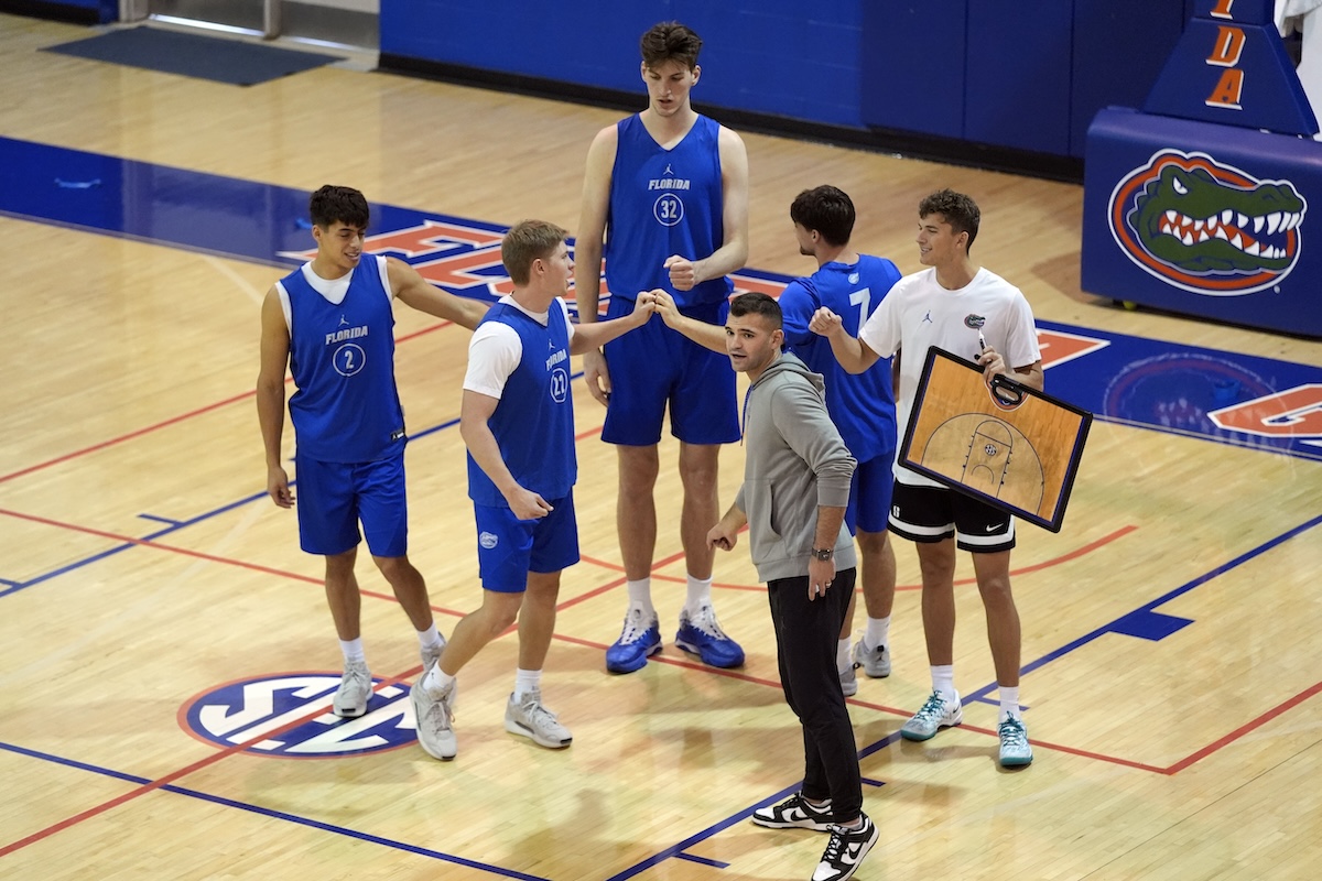 Olivier Rioux, back center, a 7-foot-9 NCAA college basketball player at Florida, gathers with coaches and teammates at the team's practice, Friday, Oct. 18, 2024, in Gainesville, Fla. 