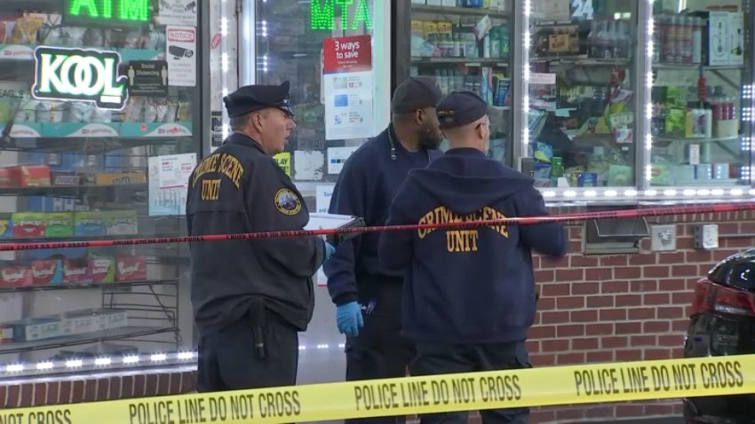 Crime scene investigators in front of West Philadelphia gas station