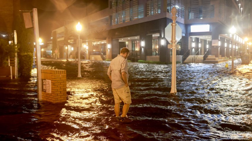 Brandon Marlow walks through surge waters flooding the street after Hurricane Milton came ashore in the Sarasota area on October 09, 2024, in Fort Myers, Florida.