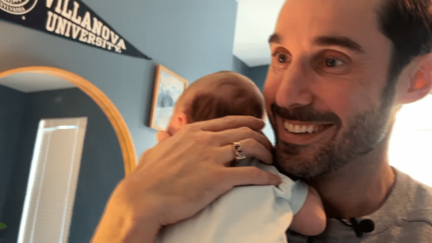 Keith Jones smiling while holding child