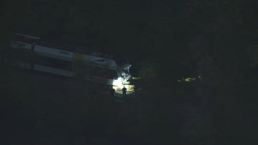 Workers investigate an NJ River Line train after a deadly crash on Monday, Oct. 14, 2024.