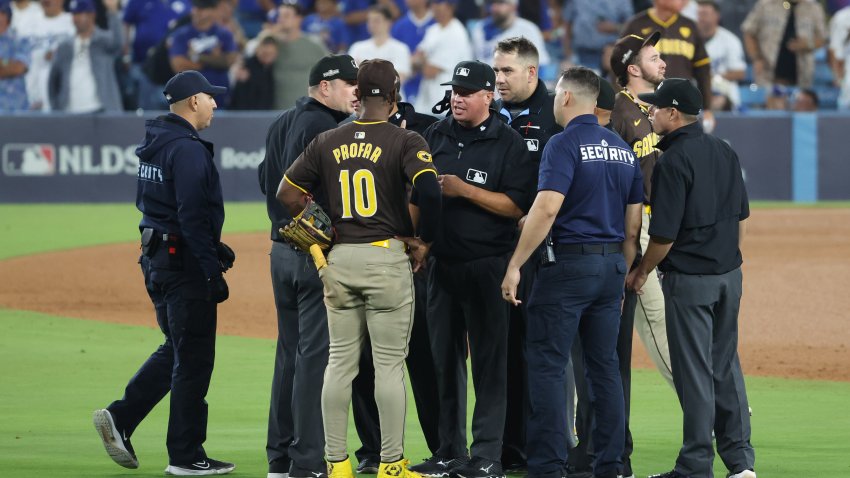 Oct 6, 2024; Los Angeles, California, USA; San Diego Padres outfielder Jurickson Profar (10) talks with umpires and security in the seventh inning against the Los Angeles Dodgers during game two of the NLDS for the 2024 MLB Playoffs at Dodger Stadium. Mandatory Credit: Kiyoshi Mio-Imagn Images