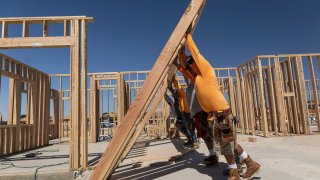 Contractors raise a framed wall on a house under construction at the Toll Brothers Regency at Folsom Ranch community in Folsom, California, on May 18, 2023.