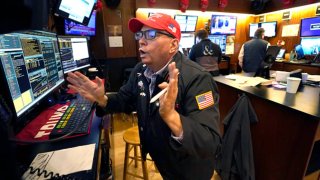 Trader Jonathan Mueller wears a Trump hat as he works on the floor of the New York Stock Exchange (NYSE) at the opening bell on November 6, 2024, in New York City.