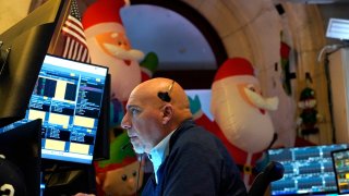 A trader works on the floor of the New York Stock Exchange (NYSE) at the opening bell on November 26, 2024, in New York City. 